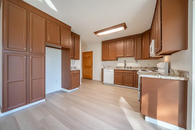 a spacious bathroom with a granite countertop sink toilet a mirror and a vanity