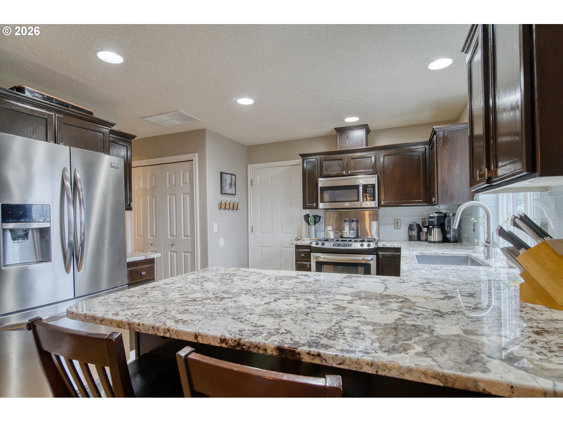 59016 Timberline Avenue St. Helens, OR 97051 - Photo 11 of 36 a kitchen with stainless steel appliances granite countertop a sink refrigerator and cabinets