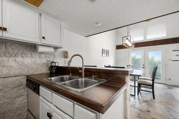 a kitchen with stainless steel appliances granite countertop a sink and a white cabinets