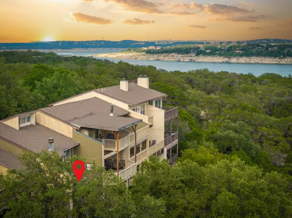 an aerial view of a house with a garden and lake view