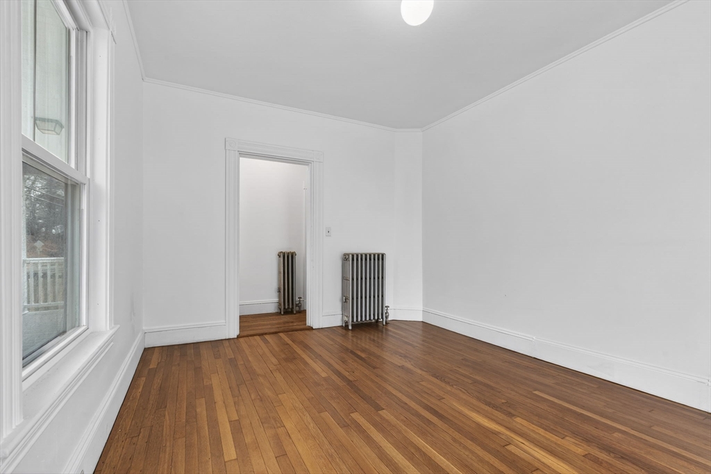 168 Elliot Street, Unit 1 Newton, MA 02464 - Photo 12 of 15 an empty room with wooden floor and windows