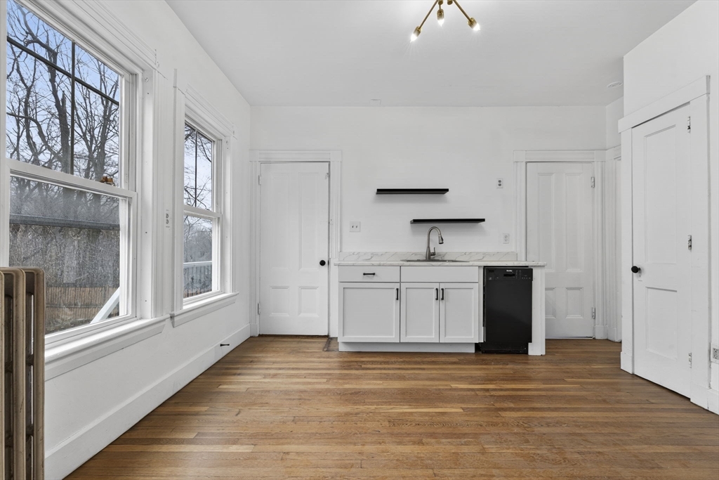 168 Elliot Street, Unit 1 Newton, MA 02464 - Photo 2 of 15 a kitchen with stainless steel appliances a stove top oven and a refrigerator