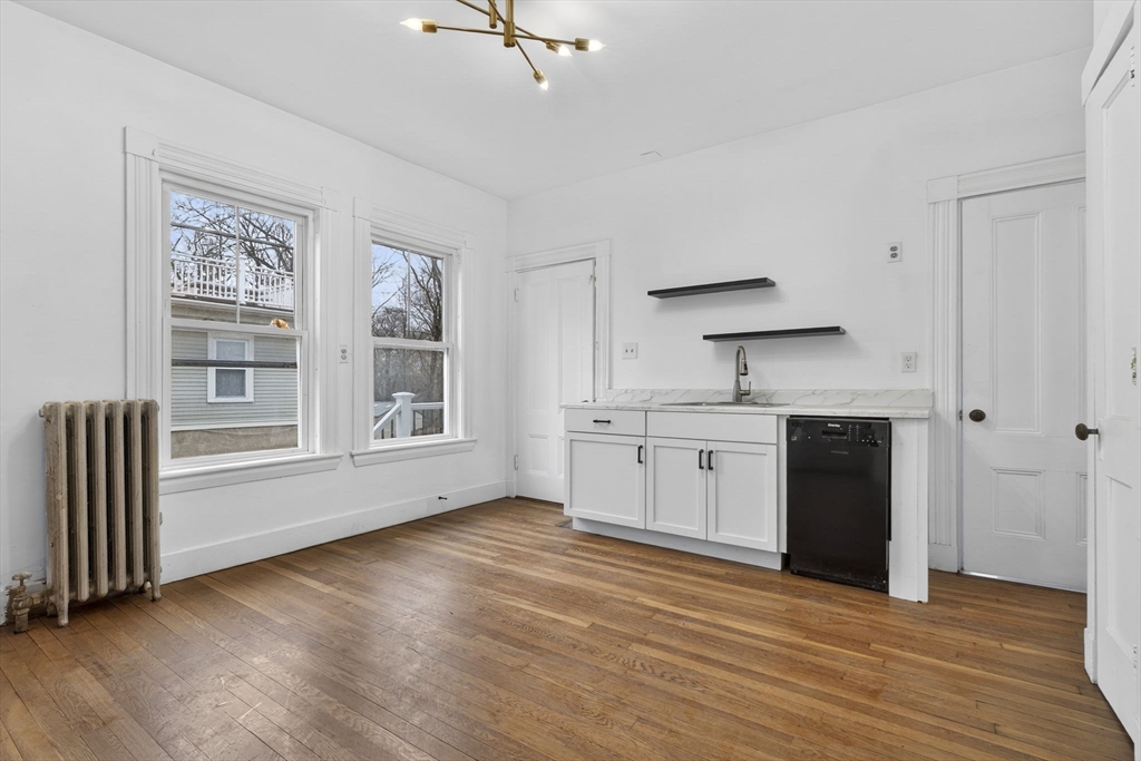 168 Elliot Street, Unit 1 Newton, MA 02464 - Photo 3 of 15 a kitchen with stainless steel appliances granite countertop a stove a sink and a refrigerator with white cabinets