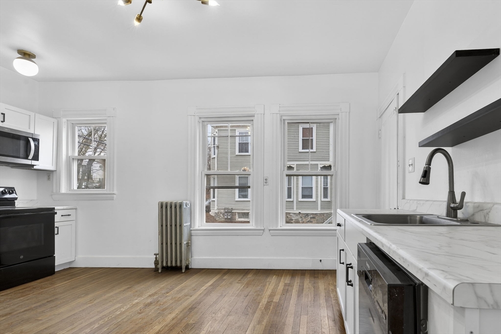 168 Elliot Street, Unit 1 Newton, MA 02464 - Photo 4 of 15 a view of kitchen with wooden floor and electronic appliances
