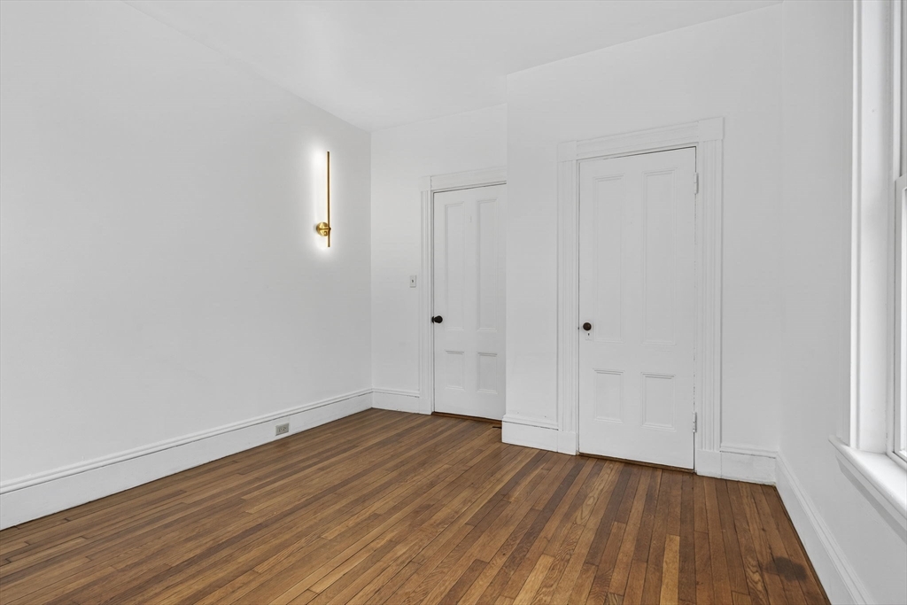168 Elliot Street, Unit 1 Newton, MA 02464 - Photo 7 of 15 a view of a room with wooden floor and white doors