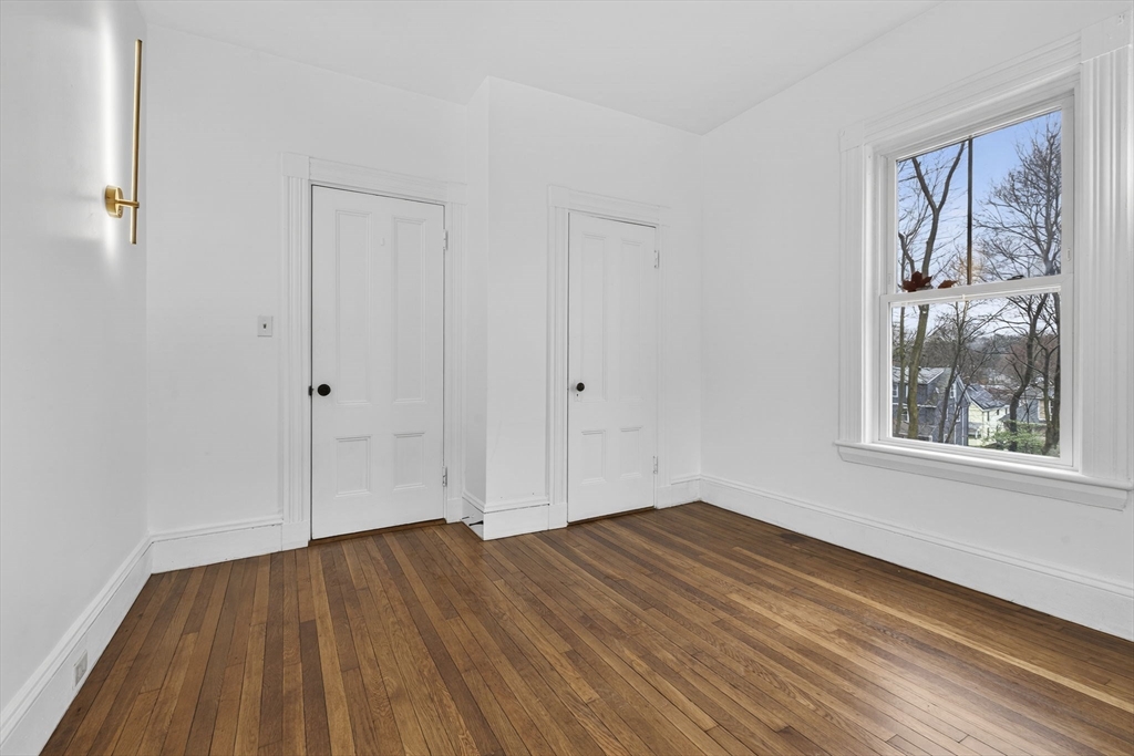 168 Elliot Street, Unit 1 Newton, MA 02464 - Photo 8 of 15 a view of empty room with wooden floor and fan