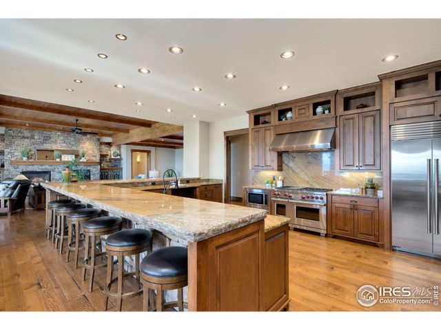 a kitchen with stainless steel appliances granite countertop a kitchen island a stove and a sink