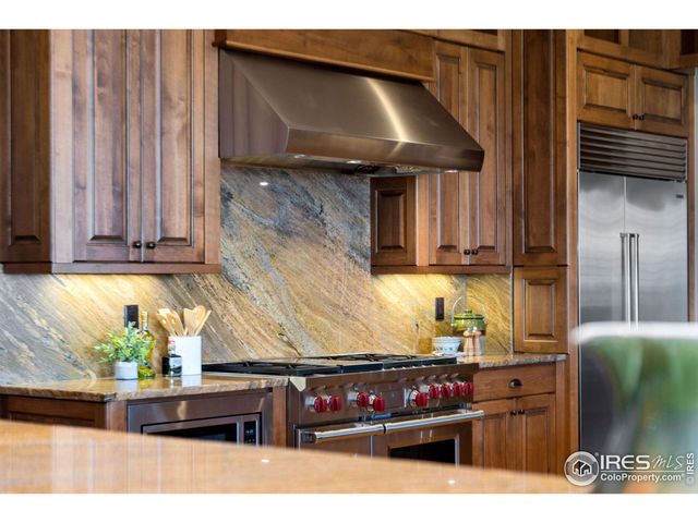 a kitchen with stainless steel appliances kitchen island granite countertop a refrigerator