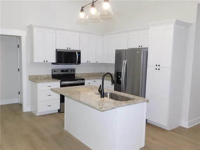 a kitchen with appliances a sink and a refrigerator