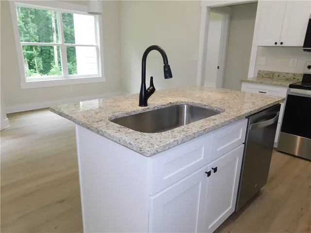 a view with granite countertop a sink and a window