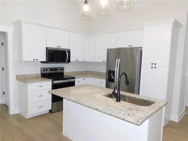a kitchen with stainless steel appliances granite countertop a sink refrigerator and microwave