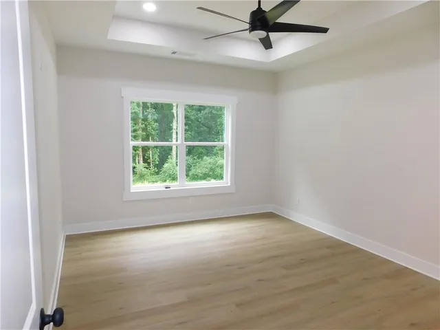 an empty room with a window and a ceiling fan