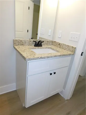 a bathroom with a granite countertop sink and a mirror