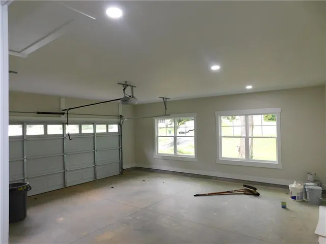an empty room with windows and ceiling fan