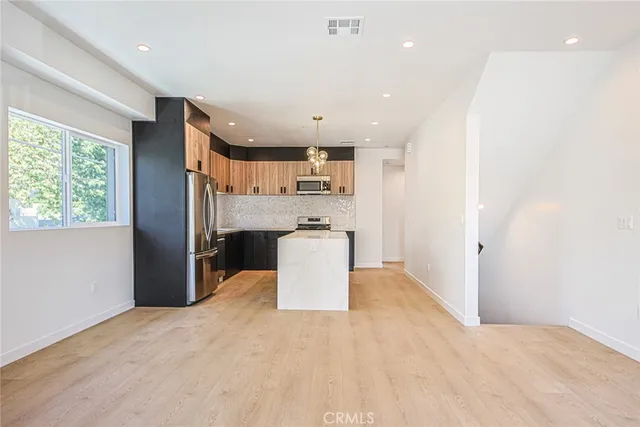a view of kitchen with stainless steel appliances cabinets and wooden floor