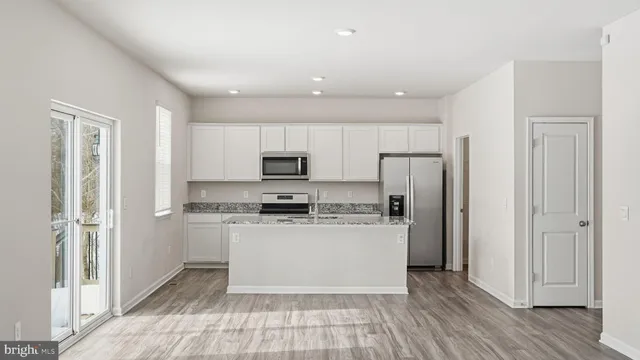 a kitchen with stainless steel appliances a refrigerator and a stove top oven
