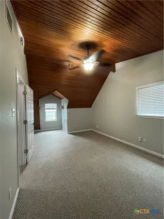 en empty room with windows and ceiling fan
