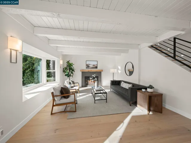 a living room with furniture a fireplace and a large window