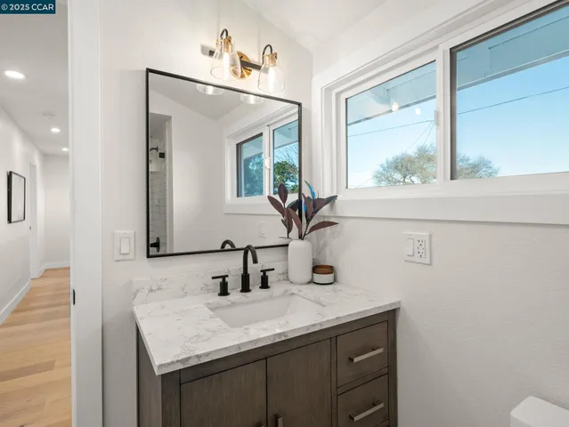 a bathroom with a mirror a double vanity and a sink