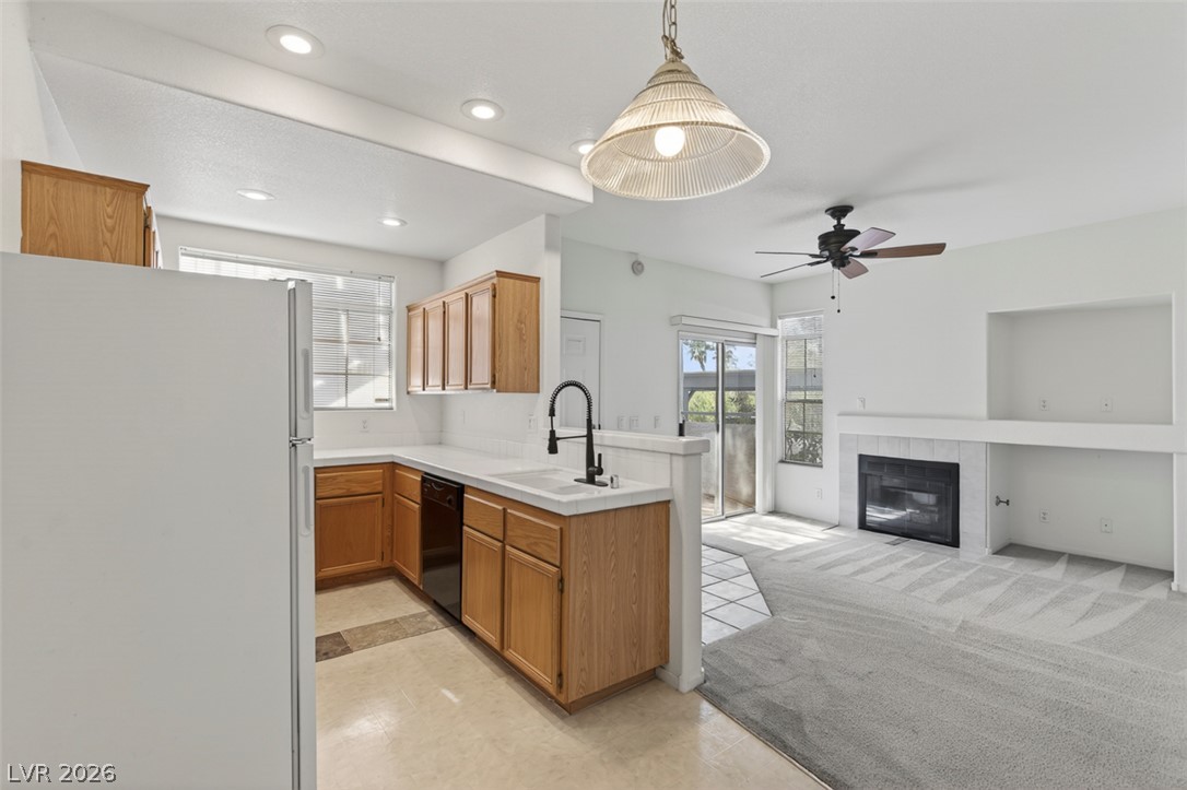2201 Ramsgate Drive, Unit 1011 Henderson, NV 89074 - Photo 12 of 40 A contemporary open-concept layout unites the kitchen and living area, complete with a cozy fireplace.
