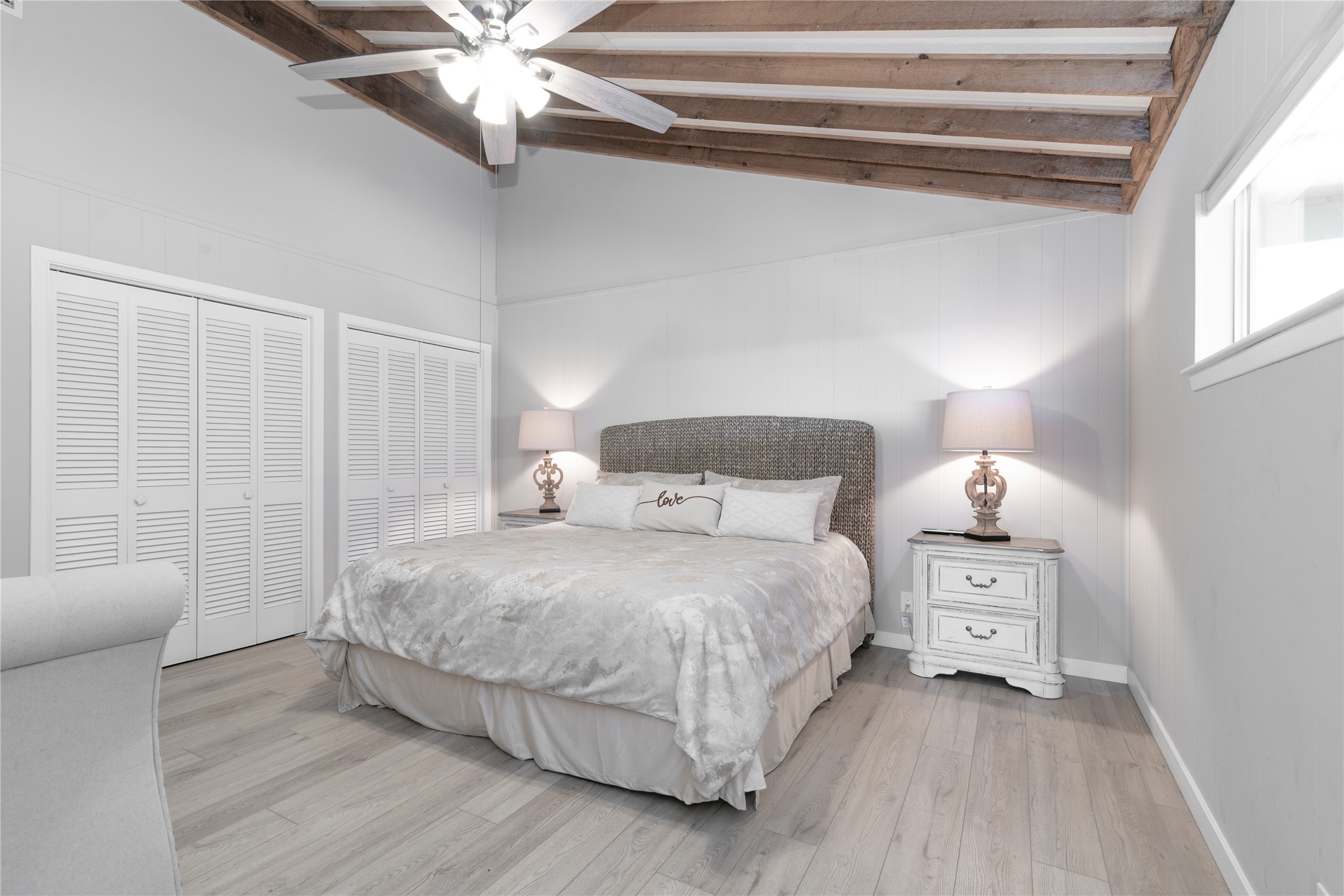 3807 Boat Dock Road Lago Vista, TX 78645 - Photo 11 of 37 Natural light illuminates this bedroom, offering light wood flooring and architectural exposed ceiling beams.