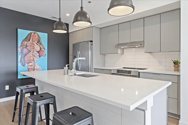 a kitchen with stainless steel appliances a sink a stove a refrigerator and cabinets