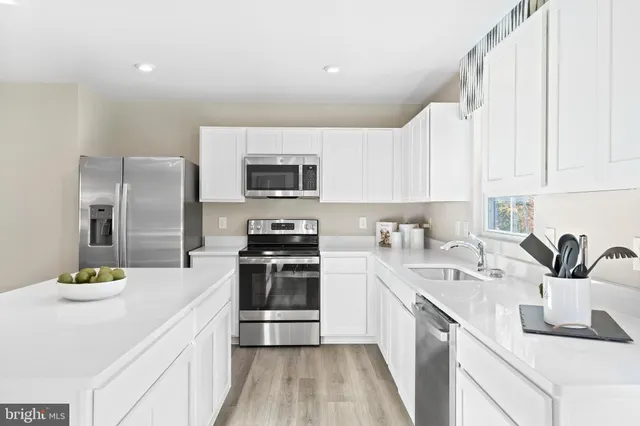 a kitchen with kitchen island a sink appliances and cabinets