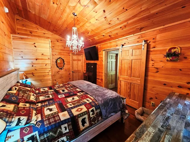 a bedroom with a bed and a dresser with the shower