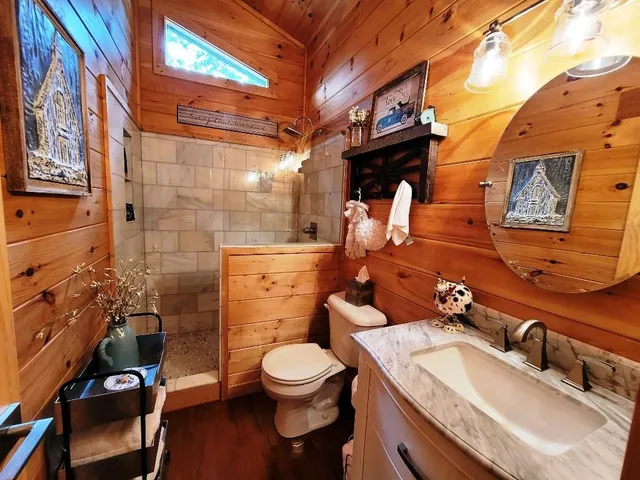 a bathroom with a granite countertop toilet sink and mirror
