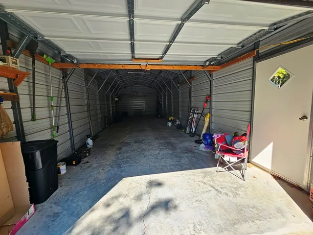 a backyard of a house with table and chairs and wooden fence