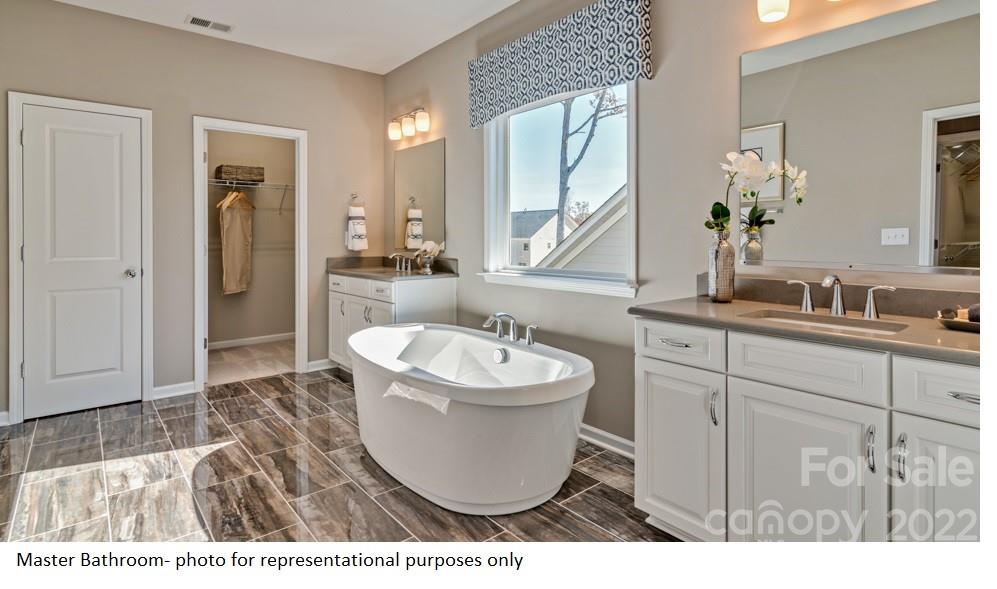 4039 Charlton Road, Unit 276 Fort Mill, SC 29715 - Photo 25 of 29 a bathroom with a sink a bathtub a mirror and vanity