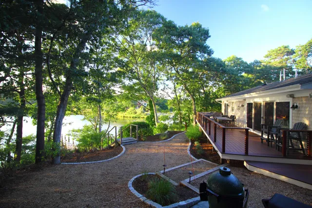 a view of a patio with table and chairs potted plants and large tree