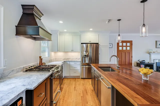 a kitchen with stainless steel appliances granite countertop a sink a stove and a refrigerator