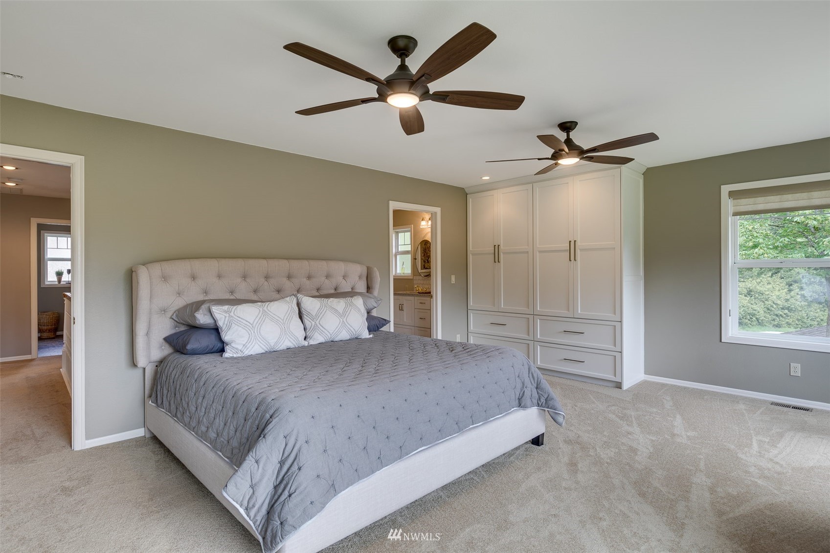 14919 Westwick Road Snohomish, WA 98290 - Photo 27 of 37 a bedroom with a large bed a ceiling fan and a large window