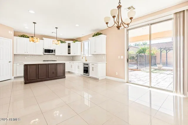 a large kitchen with stainless steel appliances granite countertop a stove a sink and a refrigerator