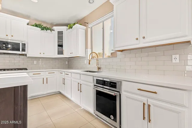 a kitchen with stainless steel appliances granite countertop a sink a stove and a refrigerator