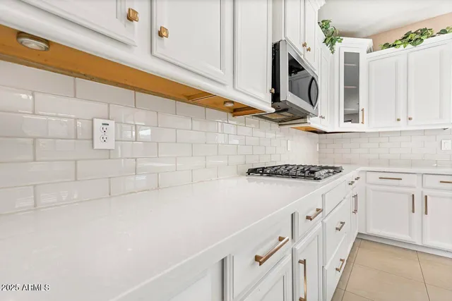 a kitchen with a stove and a table chair