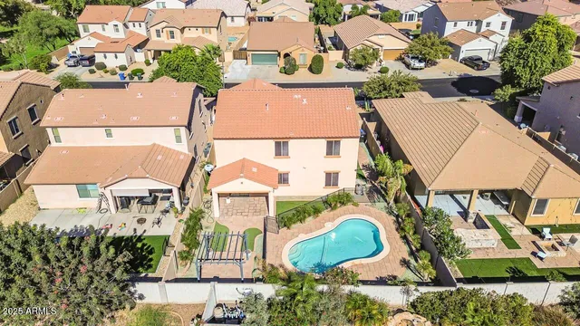 an aerial view of a house with swimming pool and outdoor seating