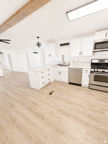 131 Rickie Road Washington, UT 84780 - Photo 12 of 31 Modern kitchen featuring white cabinetry, stainless steel appliances, and a peninsula with storage