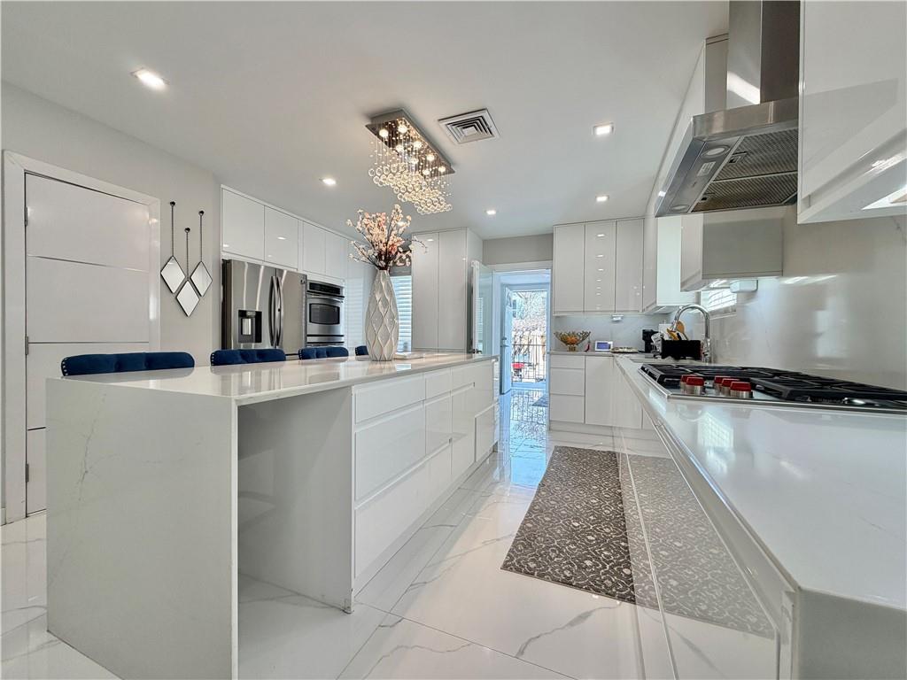 463 82nd Street Brooklyn, NY 11209 - Photo 5 of 16 a large white kitchen with a large counter top appliances and cabinets