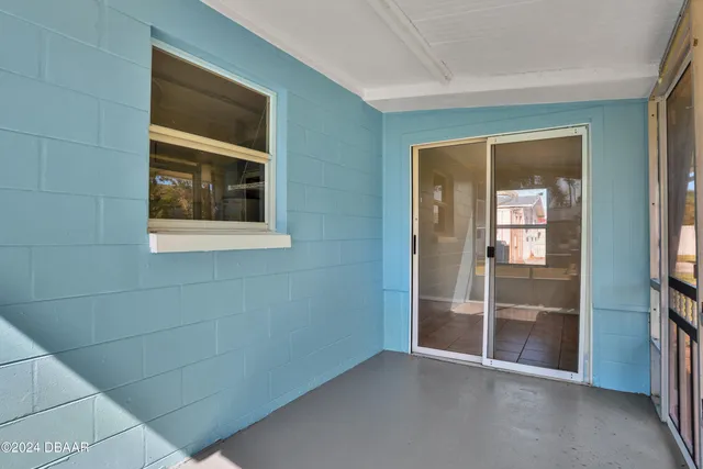 a view of an empty room with closet and a window