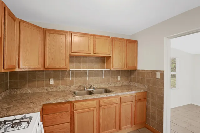a kitchen with granite countertop white cabinets and sink