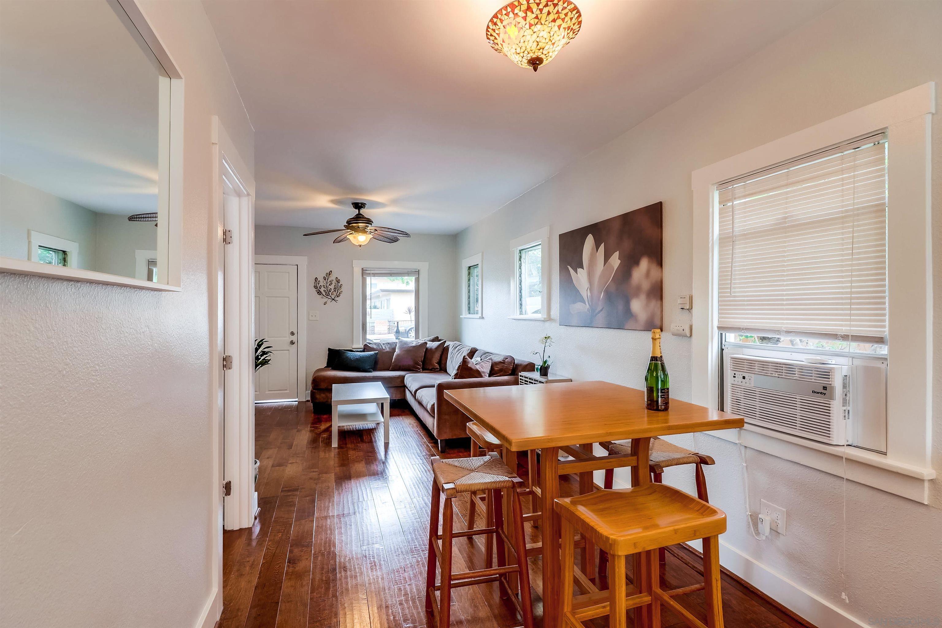 385 Nautilus Street La Jolla, CA 92037 - Photo 5 of 10 a dining room with wooden floor and chandelier