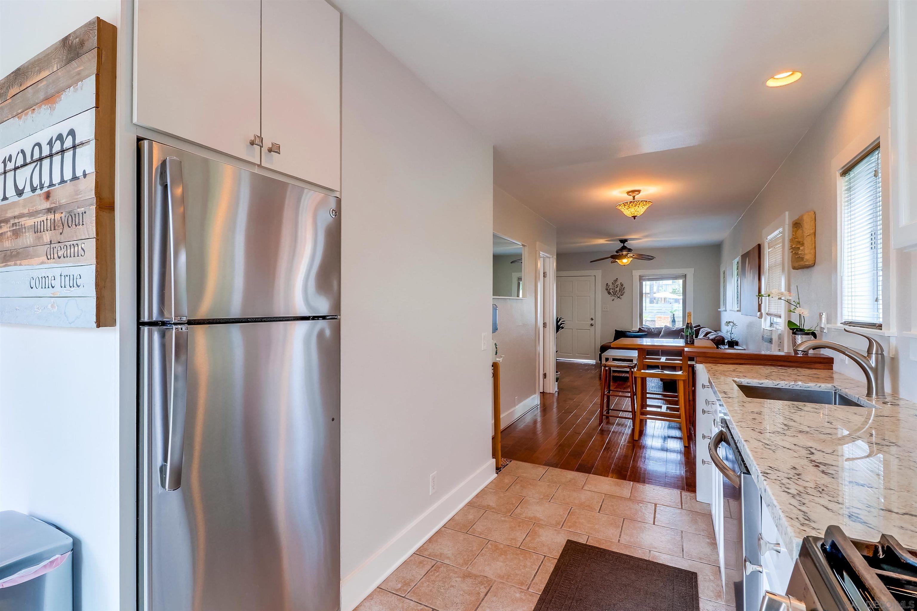 385 Nautilus Street La Jolla, CA 92037 - Photo 7 of 10 a kitchen with stainless steel appliances granite countertop a refrigerator and a stove top oven
