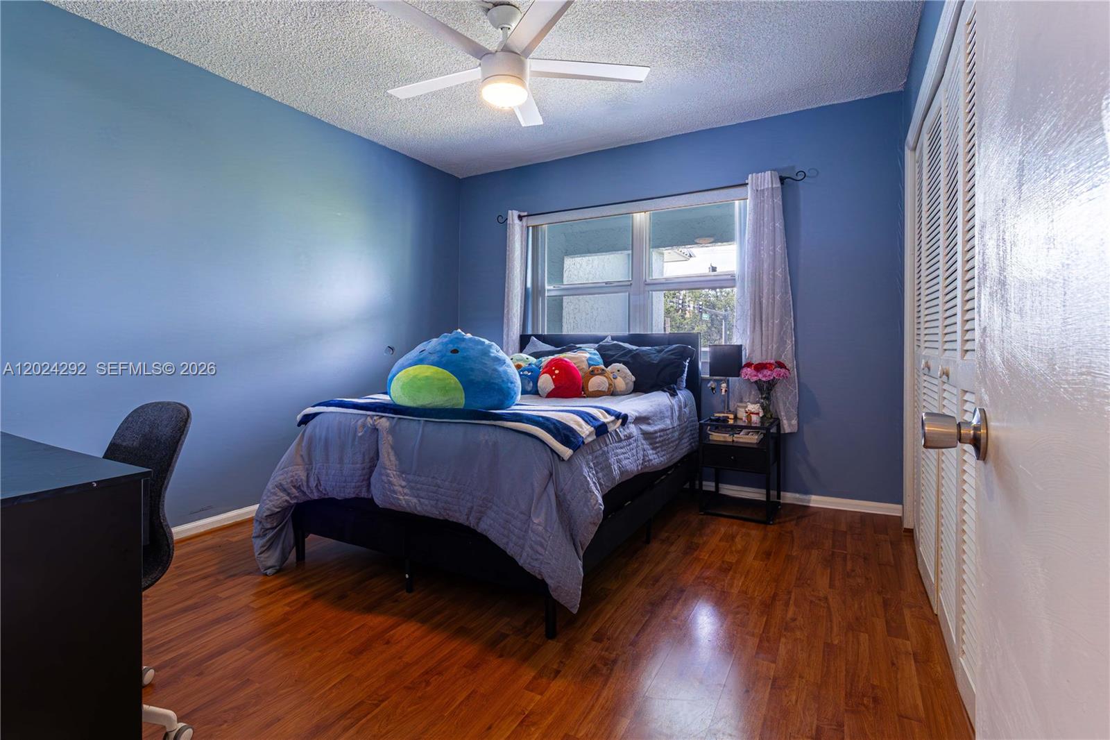 9780 Marina Boulevard, Unit 424 Boca Raton, FL 33428 - Photo 16 of 32 a bedroom with a bed and wooden floor