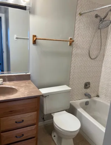 a white toilet sitting next to a shower
