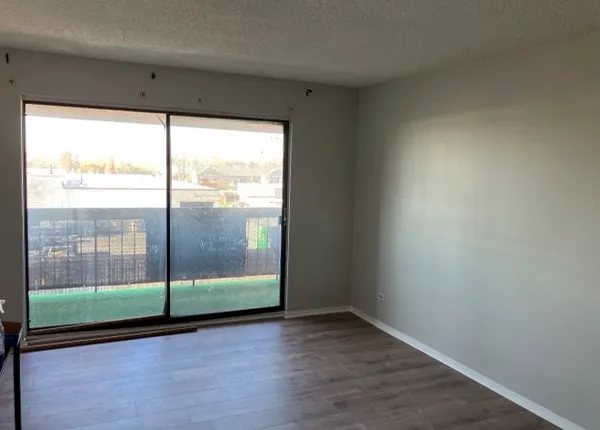 a view of a room with wooden floor and cabinets