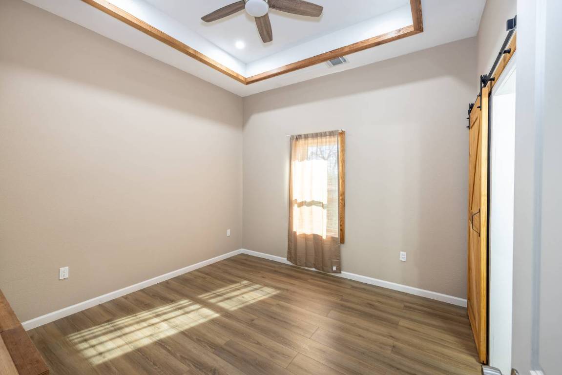 304 East 9th Nordheim, TX 78141 - Photo 11 of 33 an empty room with wooden floor and windows