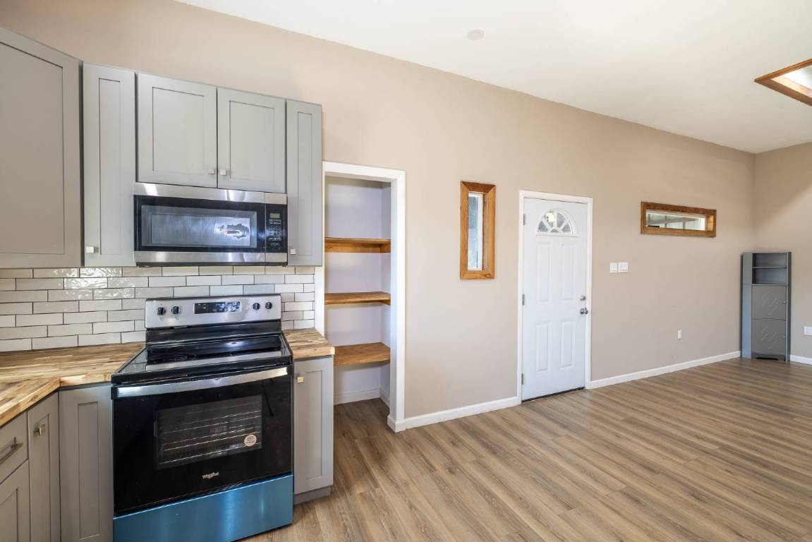 304 East 9th Nordheim, TX 78141 - Photo 6 of 33 a kitchen with granite countertop a stove and a microwave oven