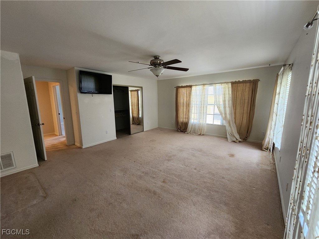 5390 Park Road, Unit 1 Fort Myers, FL 33908 - Photo 8 of 14 an empty room with windows and a ceiling fan